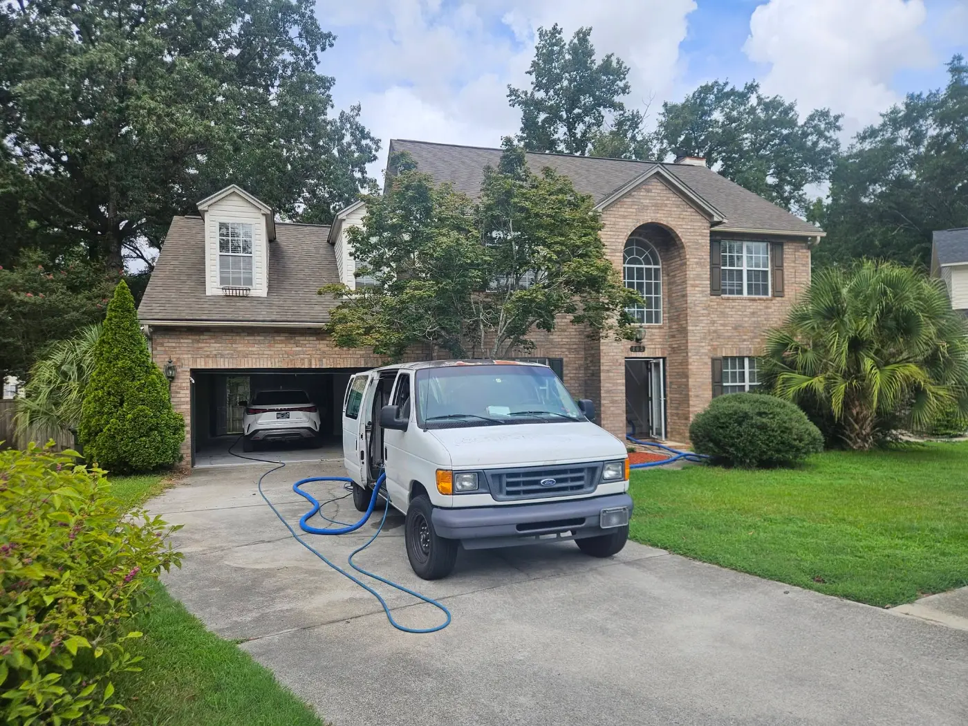 Elite Carpet Cleaning work van parked at a customer’s home in Summerville, SC, hoses run to the front door